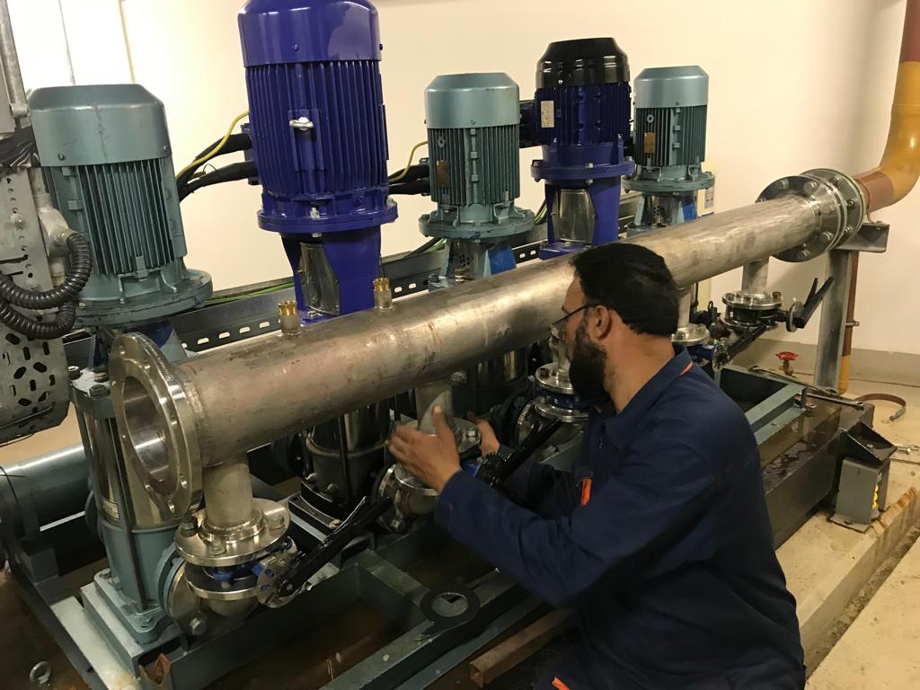 Technicians installing pipework and pumps