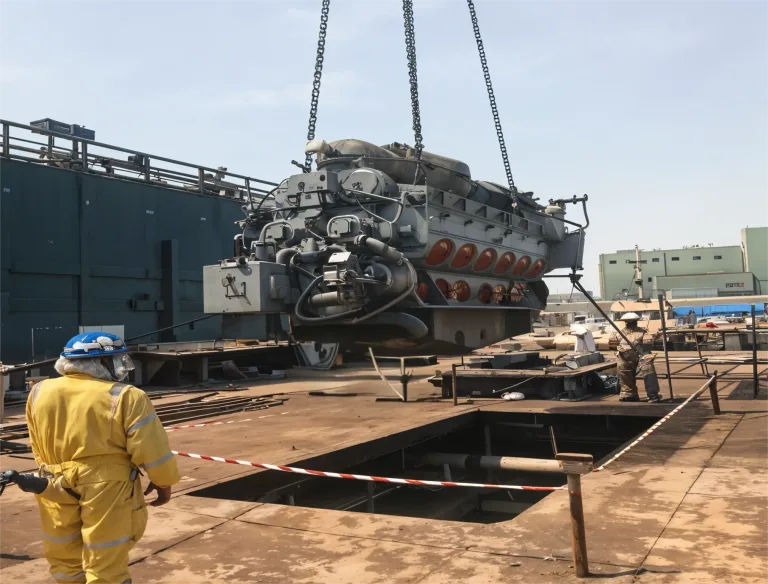 Marine diesel engine lifted out for overhaul at the dry dock