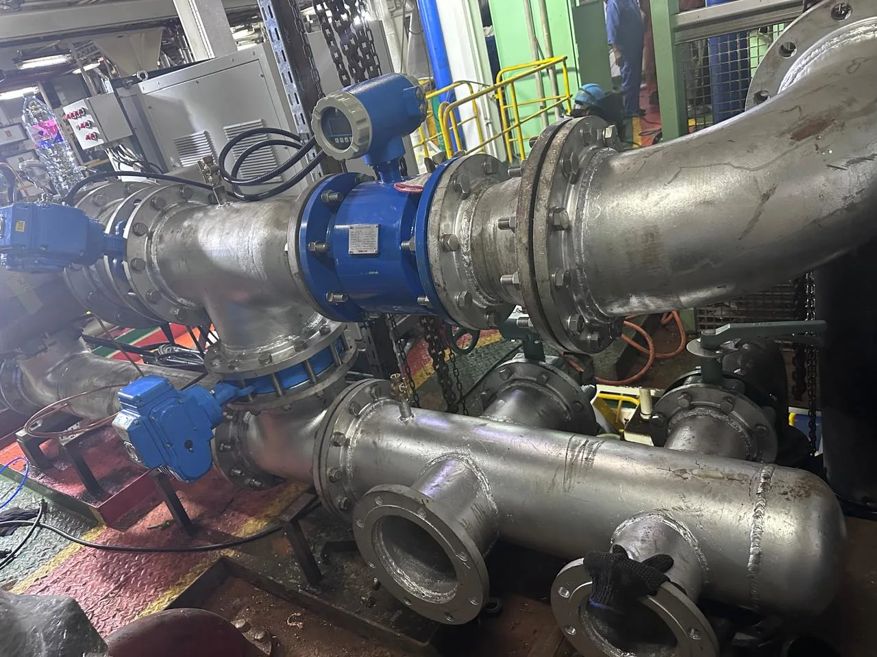 Ballast water treatment system pipework, flow meter and electrically actuated valves installed in a ship engine room
