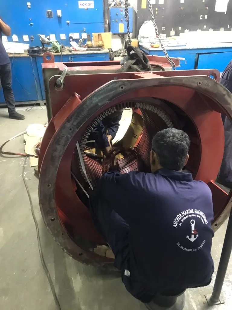 Anchor Marine Engineering technician working inside a large motor stator during rewinding